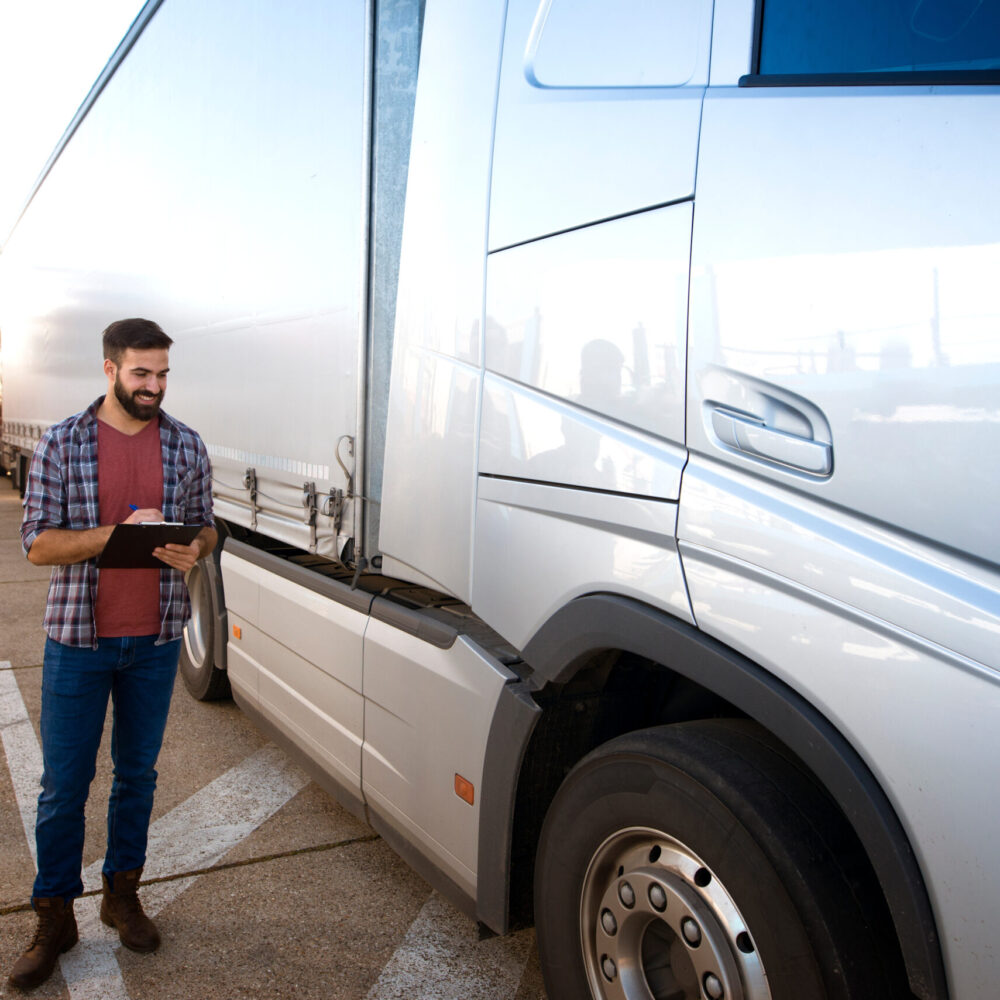 Truck driver occupation. Trucker checking vehicle condition. Experienced truck driver making visual inspection of truck before drive. Transportation service.